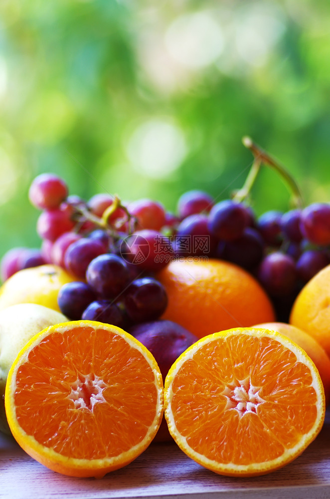 多汁的甜切片橙子和葡萄绿色背景自然图片