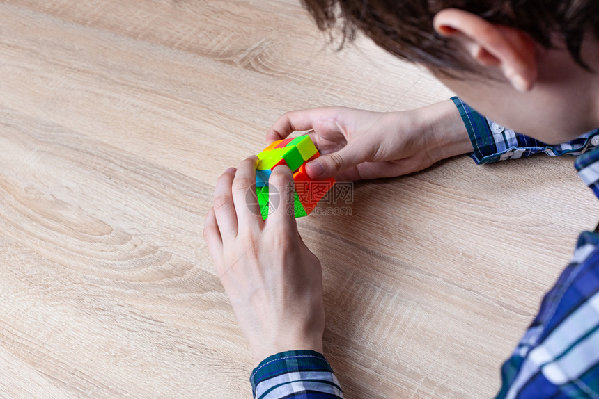 谜玩具年轻人握着rebikrsquos立方体并用它玩年轻的图片