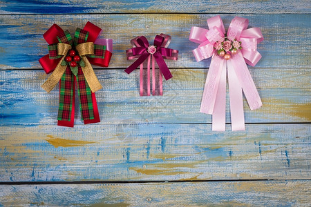 圣诞织物在彩色木背景上的弓展示木制丝带背景图片