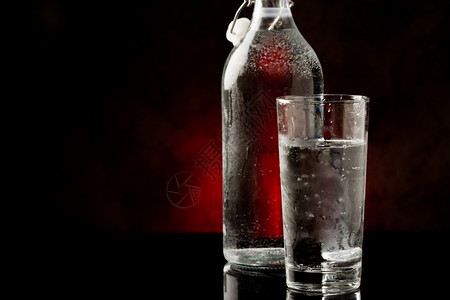 力气口渴反射生活黑色玻璃桌上的水杯和瓶子相照片背景