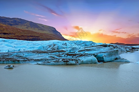 冰川泻湖日落时冰岛的Jokulsarlon冰川和湖泊户外火成岩石背景