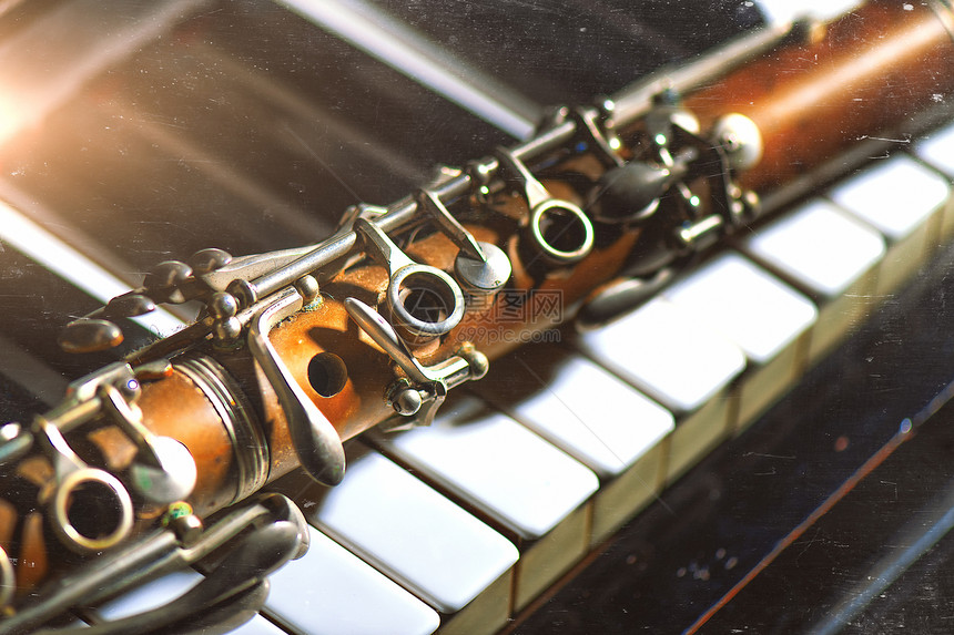 音乐家笔记爵士古老效果照片缩在钢琴键盘上的安蒂克单簧管图片