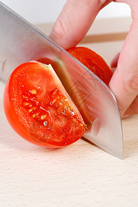 蔬菜新鲜的锋利女用刀砍手切新鲜红西番茄高清图片