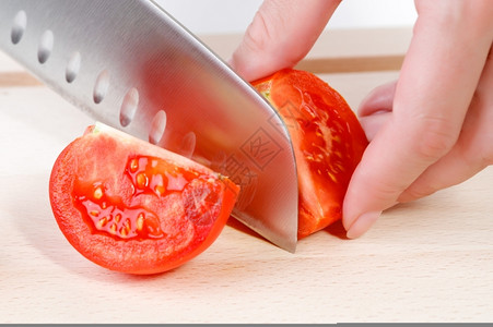 女用刀砍手切新鲜红西番茄晚餐蔬菜白种人高清图片