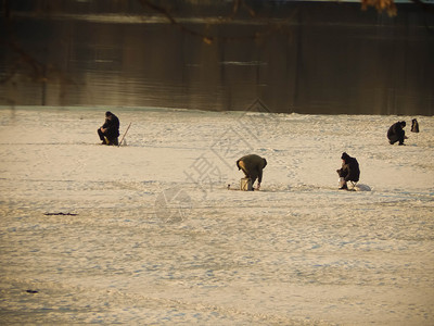 闲暇渔民坐在冰上河钓鱼渔夫男人图片