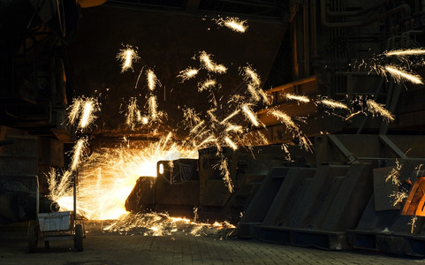 巨大的钻井在工业熔炉中制造一个灌满洞火花到处飞来去钻头熔化热的背景图片