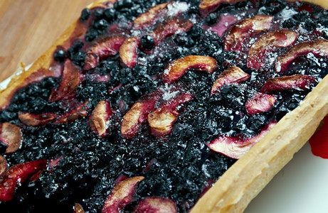 甜点生锈木制桌上的蓝莓派和浆果木头覆盆子图片