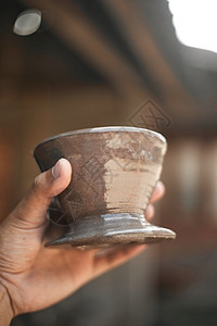 酿造杯子近手握着模糊背景的滴水器陶瓷近手握着滴水器陶瓷咖啡因背景图片