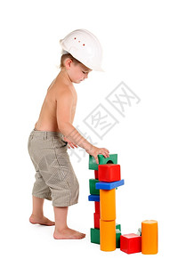 建筑学俏皮小男孩在白色背景上盖了一栋玩具屋堵塞图片
