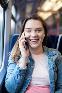 通勤者青年女子在火车旅程中用移动电话交谈称呼铁路乘客高清图片素材