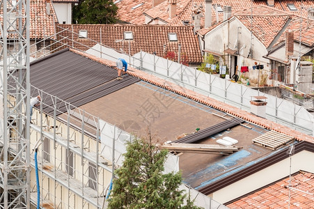 建筑屋顶大楼翻修的工人建筑房顶改造中的工人定影一种装修图片