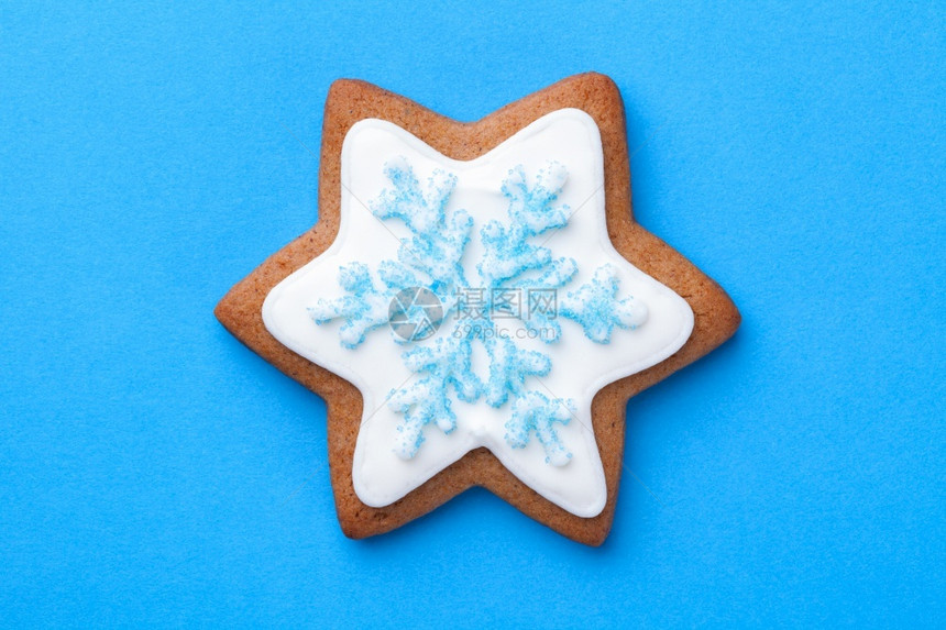 美丽的圣诞节姜饼明星干蓝底有雪花和烘烤的糖自制图片