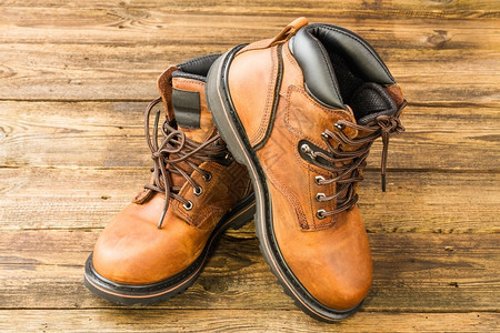 蹦极新的木制背景棕褐皮靴子革图片