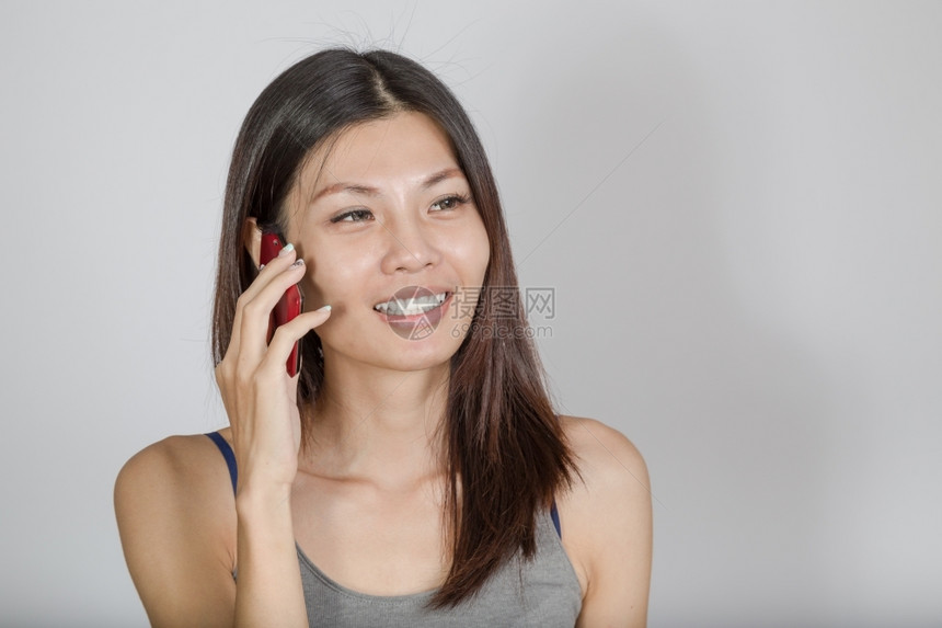 微笑的女人在用智能手机说话成人技术图片