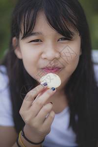 可爱的亚洲人近距离面对亚裔少年以幸福的面相吃零食脸图片
