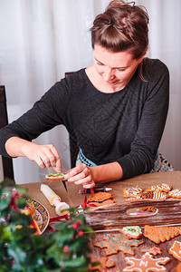传统准备女人装饰着烤圣诞姜饼和糖霜装饰风格图片