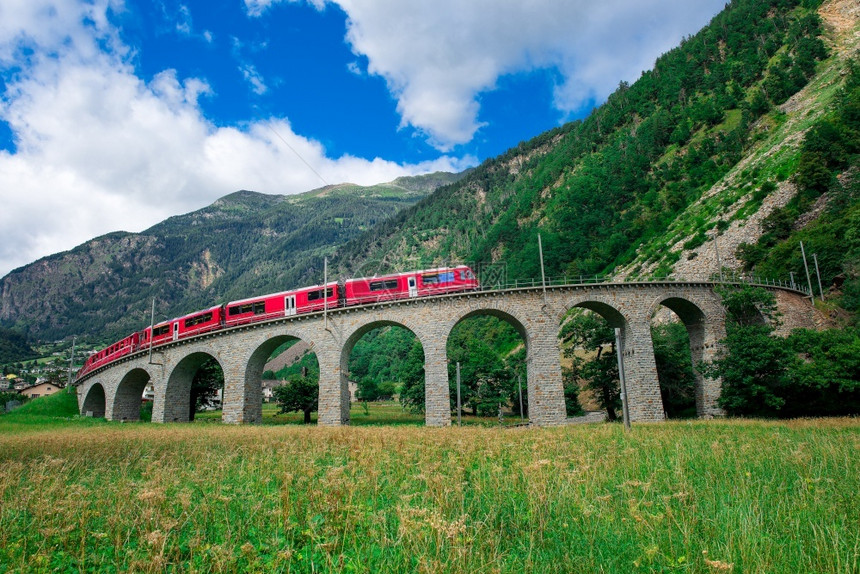 瑞士山火车BerninaExpress穿越环绕的桥以在夏季升空伯尼娜圆圈风景优美图片