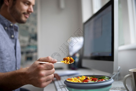 白饭桌子在职的办公室男工人在吃健康织女午餐图片