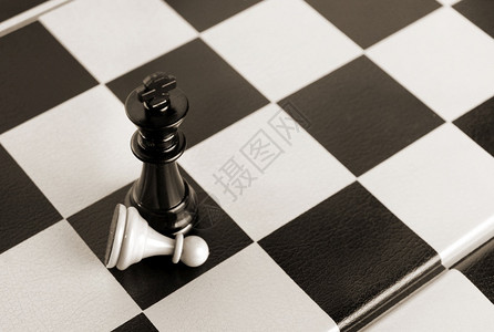 棋盘战略国际象游戏黑王击败白棋子战斗图片
