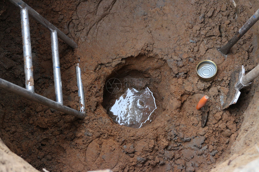 土地坑下水已经出现在深圆井底部并用手动工具拥有图片