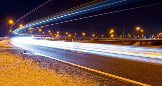 冬季晚上在一条高速公路上输油管的交通过境货车弯曲图片
