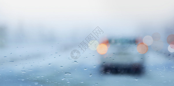 下雨的一天车窗上有雨滴交通灯明亮夜晚路液体湿的高清图片素材