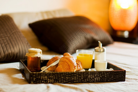 橙枕头一张在卧室内床上有早餐食物的托盘照片蜜糖果汁高清图片素材