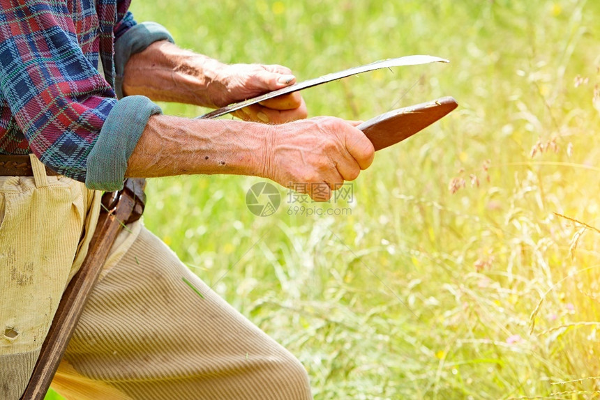为了农村工作夫用胡子磨利他的刀用它来割草这在传统上是图片