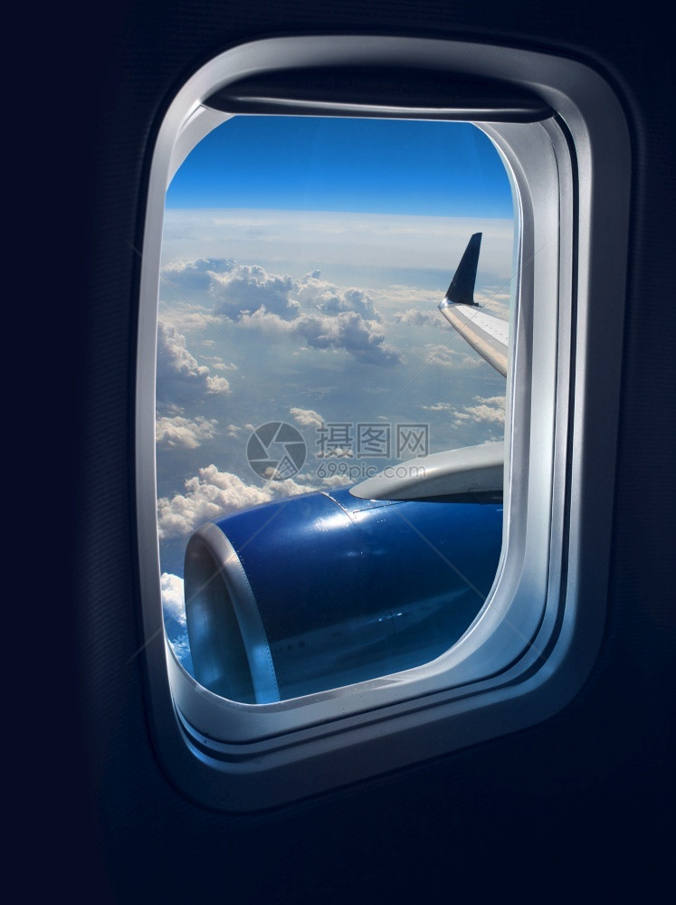 航空白色的从蓝天上空高处的喷气飞机窗口上看到云景图片