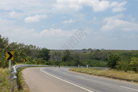 箭黄色的带有障碍和警告曲线路标志的农村道车图片