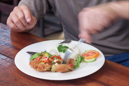 美味的沙拉餐盘男人吃炸鸡翅和茉米饭在白盘餐时间图片