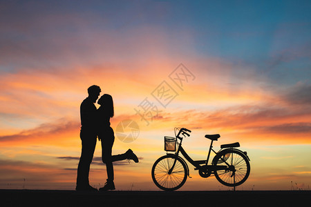女朋友浪漫的热恋中情侣在日落时接吻的剪影热恋中情侣剪影年轻图片