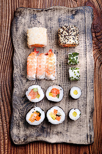 新鲜的一顿饭小吃上面木制桌手工作的陶瓷板上寿司图片