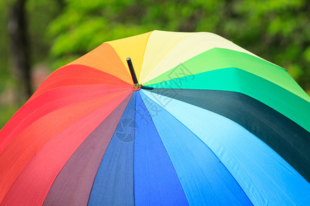 目的天气彩虹色伞绿背景的彩虹伞外部图片