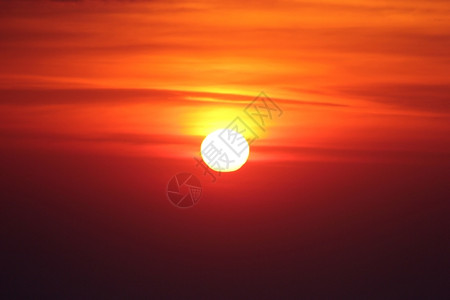 晴天热的闪耀红色和黄天空背景下的大明太阳图片