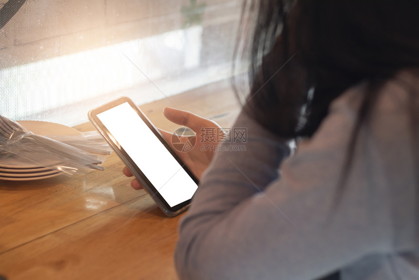 互联网社会的在咖啡店用智能手机抓着女人保持图片