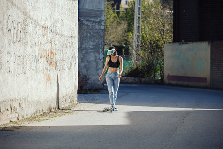 80年代独自的遮阳板女孩与她的滑冰在镇路上图片