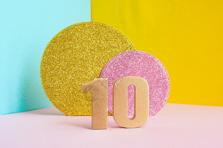 10号金黄在多色蓝粉和两颗闪亮金子粉红色圆圈的蓝黄粉背景上祝生日贺卡概念快乐一种明亮的信片背景图片