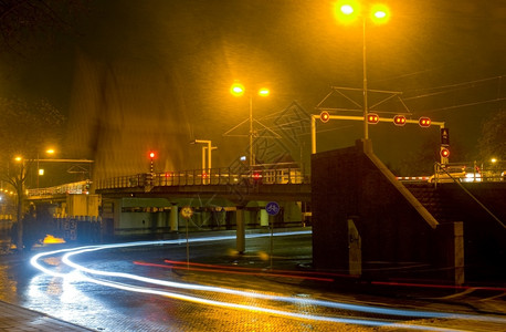 一种街道风暴辆汽车和有电缆的汽车等待桥在寒冬夜猛烈淋浴时关闭图片