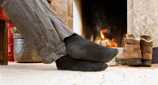 自在徒步者的脚火边升起冬天地毯家高清图片素材