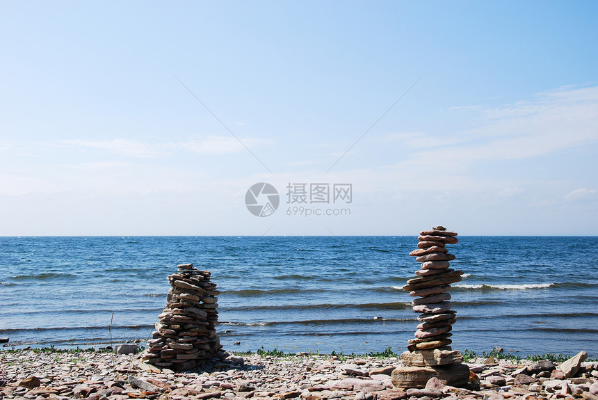 瑞典晴天平衡海岸的两座石头雕塑有波浪和蓝水图片