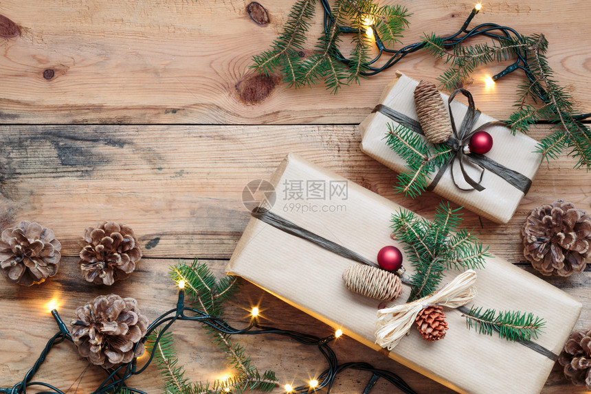 松果季节地面圣诞礼物在树下赠品包装在纸上饰着圆锥和松树枝放在木制地板上从以复制空间看图象顶部的文字图片