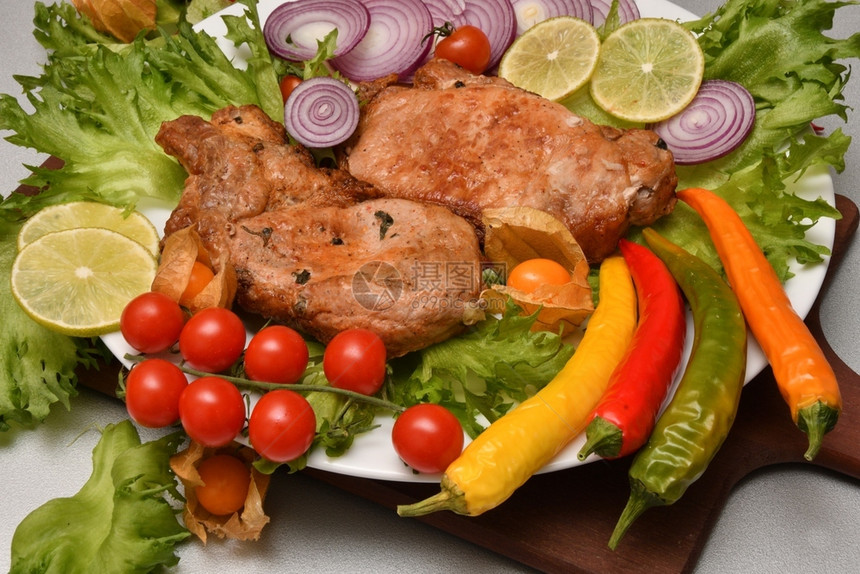 烤猪肉和蔬菜摆盘图片