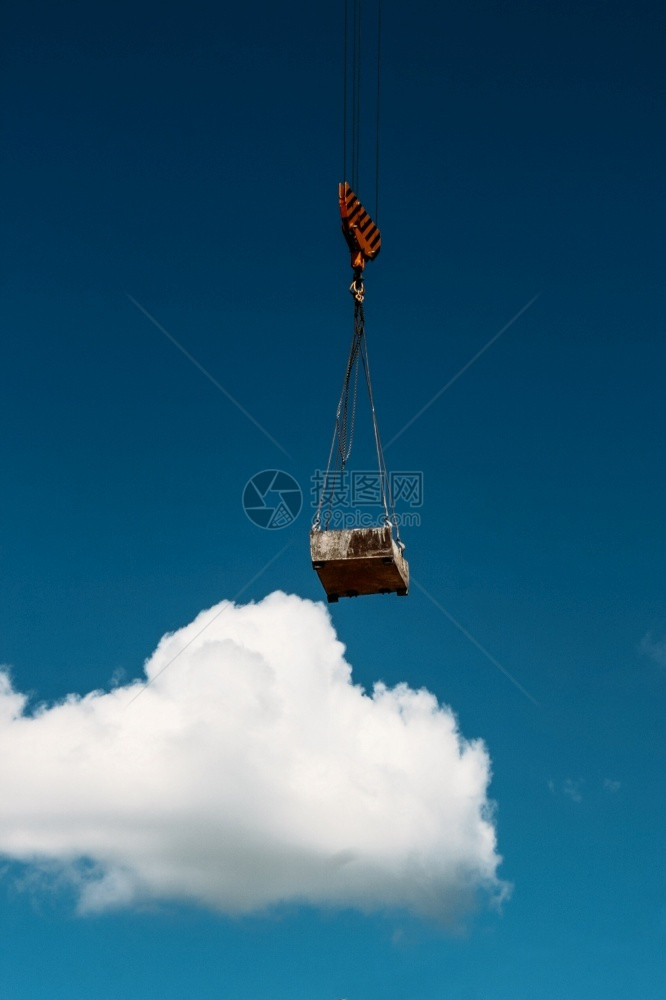 建造一座蓝色天空和云彩的新建筑时升起高塔重机电梯进步蓝色的图片