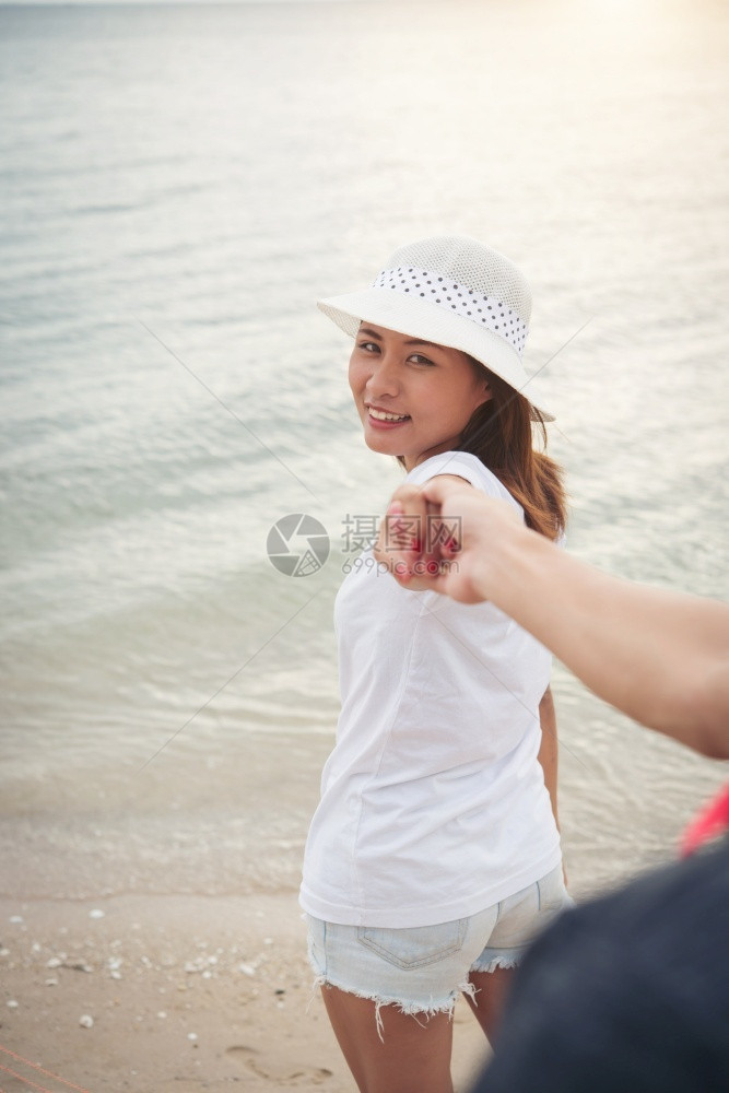 女士旅行欢迎朋友带她的男去海滩女人牵着男的手享受海滩放松恋爱的假日情侣图片