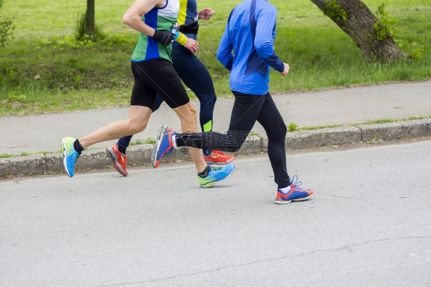 马拉松赛跑三选手在城市公路上图片