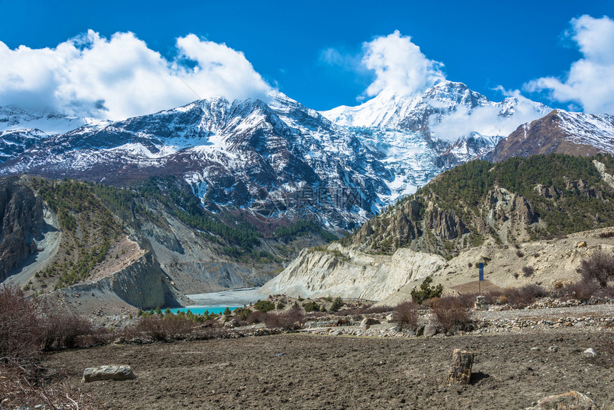 白色的旅游村庄喜马拉雅山上美丽的雪峰和云彩在尼泊尔马南村附近的一个小绿化湖图片