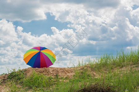 蓝色的旅行在地上躺着的彩虹伞休息图片