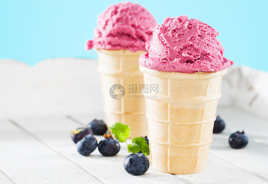 威化饼两杯蓝莓冰淇淋奶油松饼和两杯蓝莓冰淇淋花边两杯蓝莓冰淇淋蛋糕和蓝色的莓浆夹在底白木上紫色小吃图片