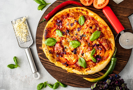 萨拉米脆皮烘烤的意大利新鲜披萨配有培根番茄和烤肉图片